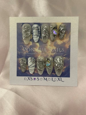 Swerly (S);Medium Almond - Unika handgjorda press-on naglar i milky white och silver. Naglarna har en medium lång mandelform och är dekorerade med handmålade 3D metallicdetaljer, holografiska stenar och swirl-mönster. Handgjorda och riktigt statement! Perfekt för dig som vill ha något extra.S: 15 mm, 11,5 mm, 12 mm, 11 mm, 9 mm 