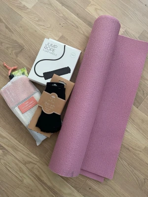 Rosa yogamatta och träningskit - Detta träningspaket innehåller en yogamatta, ett Casall hopprep med skumhandtag, ett 3-pack motståndsband i tyg och ett par yogastrumpor i ekologisk bomull, one size.  Mattan har använts 1 gång men fått fläckar för att den har stått i tvättrummet. Se bild.