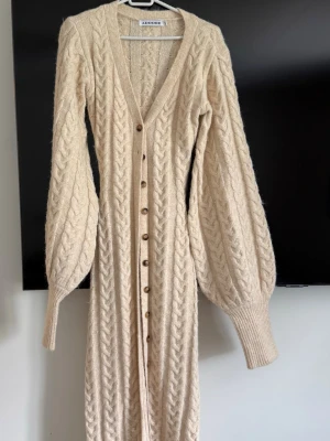 Beige lång stickad kofta/ klänning Adoore - Lång, beige stickad kofta från Adoore, använd 1 gång jätte fint skick