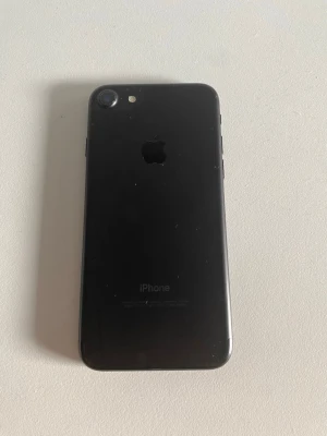 Svart iPhone med glasbaksida - Säljer en iphone 7 som fungerar mycket bra, jag har inte användt den i länge men allt är bra.