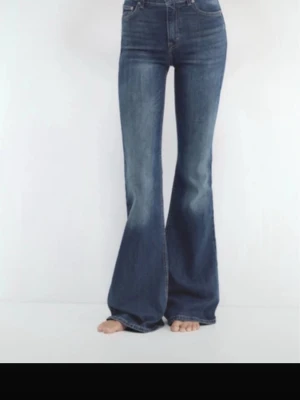 Blå utsvängda jeans med hög midja - Säljer ett par blå jeans med utsvängda ben. Klassisk femficksmodell i stretchigt denimtyg som sitter snyggt över höfterna och låren. Knappt använda(ca 3 gånger)