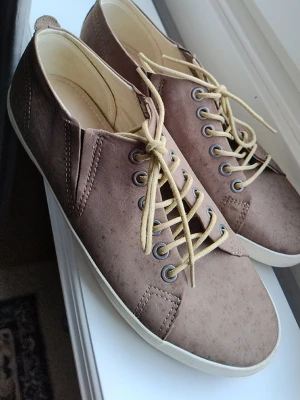 Beige sneakers från Vagabond - Snygga beige sneakers från Vagabond med lågt skaft och klassisk snörning. Skorna har en stilren design med mockaliknande material och vita sulor. Perfekta för dig som gillar en clean och enkel look. Har använd bara 2 gånger 