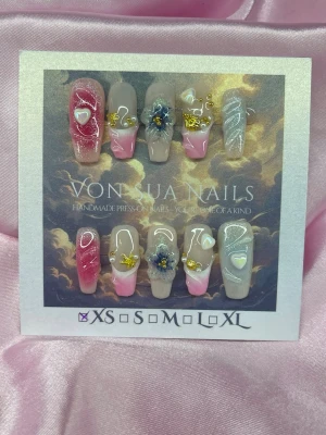 CloudKiss (XS);Medium Ballerina - Unika Handgjorda press-on naglar i mix av rosa, guld och nude med glittriga detaljer, hjärtan, handgjorda 3D-blommor och guldfärgade dekorationer. Medium långa, ballerinaform tippar som ger en lyxig och unik look. Perfekt för dig som vill ha något extra till naglarna.XS: 14 mm, 11 mm, 11,5 mm, 10 mm, 8 mm 