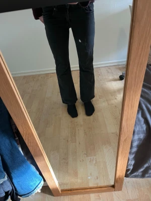 Svarta bootcut jeans - Säljer ett par svarta bootcut jeans med klassisk femficksmodell och hög midja. Jeansen har en lätt utsvängd passform nedtill och är tillverkade i ett mjukt denimtyg. Perfekta för dig som gillar en tidlös och avslappnad stil.