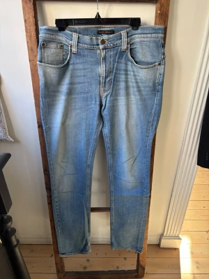 Nudie Jeans herr W34 L34 - Slim jeans från Nudie Jeans i en ljusare blå färg. Modell Thin Finn! Innerbenslängd: 84 Midja rakt över: 44.5 