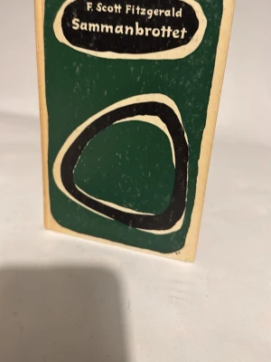 Sammanbrottet av F. Scott Fitzgerald - En klassisk skönlitterär bok med titeln 'Sammanbrottet' av F. Scott Fitzgerald. Boken har ett grönt och svart omslag med abstrakt design och mjuka former. Pocketformat med gulnad rygg och tydlig titel på både framsida och rygg. Perfekt för dig som gillar klassiker.