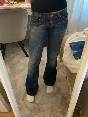 Lågmidjade bootcut jeans - Säljer ett par snygga mörkblåa lågmidjade bootcut jeans från Only i storlek 25/34, de är lite slitna på inre låret (se sista bilden) men inget som syns när man har på sig dem, annars fint skick! Innerbenslängd: 78 cm Midjemått rakt över: 36 cm