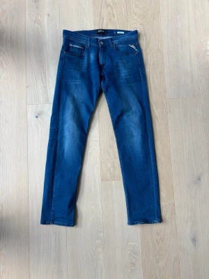 Blå slim fit jeans från Replay - Snygga blå slim fit jeans från Replay. Jeansen har normal midja, raka ben. Perfekta för en avslappnad och trendig look.
