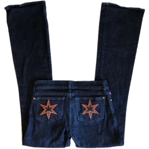 Vintage lowwaist/ lowrise bootcut/ flare jeans, y2k/ cyber/ alt/ 2000tal/ 00tal/ 2000s/ 00s/ stjärnor/ graphic  - Coola mörkblå jeans med orangea stjärnor på fickorna!