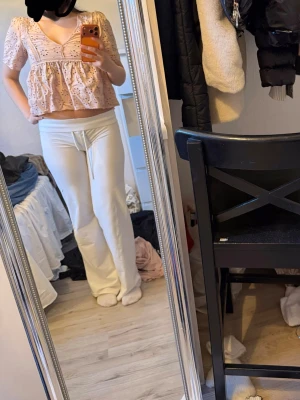 Ljusrosa broderad blus  - Supersöt ljusrosa blus  med broderade blommor och volangdetaljer. Blusen har korta ärmar och en luftig, croppad passform som ger en romantisk vibe. Perfekt för vår och sommar, till jeans eller kjol.