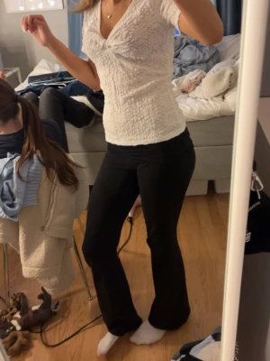 Vit smockad topp med v-ringning - Säljer en vit topp med smockat material och v-ringad hals. Toppen har korta ärmar och en figurnära passform som framhäver midjan. Perfekt för dig som gillar en enkel men ändå söt stil. toppen är helt oanvänd och har även lappen kvar.