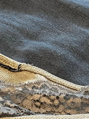 Beige loungewear topp med spetsdetaljer - Mysig beige långärmad loungewear topp med ribbad struktur och dekorativa spetsdetaljer i grått längs halsringning och nederkant. Perfekt för chill dagar hemma och har en avslappnad passform. Materialet känns mjukt och stretchigt.( jag har klippt bort lappen på tröjan men den är från Gina Tricot😉)