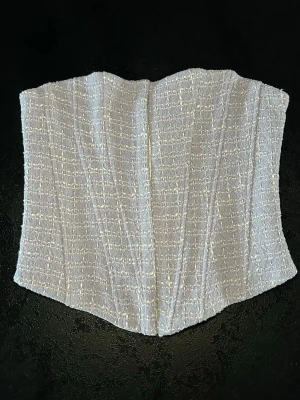 ZARA korsett topp i tweed – ljuslila – XS – ny med tags - Superfin korsett/tubtopp från ZARA i ljuslila tweed med struktur. Stadig modell med formsydda sömmar som ger en snygg siluett. Knäppning fram med hyskor. Helfodrad.  ✨ Ny med lappar kvar ✨ Storlek XS ✨ Färg: ljuslila med vita detaljer ✨ Strukturerat tweedtyg ✨ Perfekt till fest, sommar, jeans eller kostymbyxor  Aldrig använd. Säljer då den inte kommer till användning.