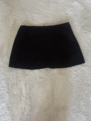 Minikjol - Enkel och stilren svart mini kjol. Kjolen har en rak passform och är perfekt för att matcha med olika toppar. Stilren design utan synliga detaljer eller mönster. Passar till allt. Den är för stor på mig och är därav endast provad, är 167 och har strl xs.