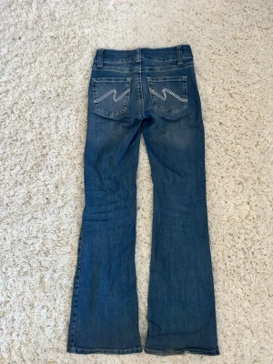Lågmidjade jeans Nelly - Lowwaisted stitch bootcut jeans ifrån Nelly i storlek 34! Precis som nya, bara lite lite avtrampade (se sista bild) knappt märkbart.  Superfina detaljer på bakfickorna och med en jättefin passform.