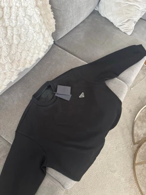 Svart sweatshirt från Prada - Svart sweatshirt från Prada tillverkad i mjukt bomullsmaterial stilren look
