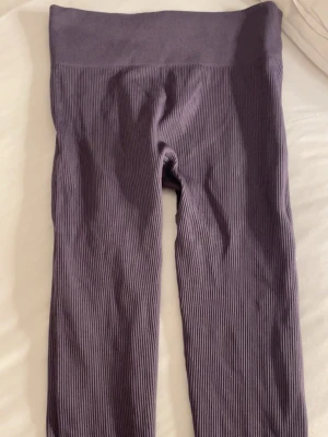 Ribbstickade mörkgråa leggings  - Säljer ett par ribbstickade leggings i en snygg mörkgråfärg. De har hög midja och är stretchiga för en bekväm passform. Perfekta till både oversized tröjor och crop tops. Materialet känns mjukt och följsamt. Och perfekt för en skön joggning dag eller gympas