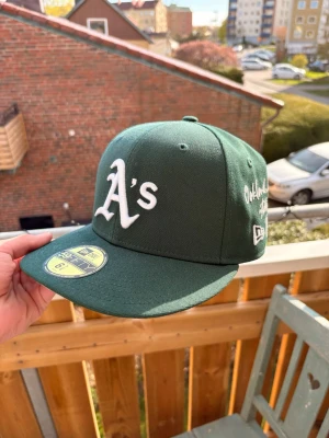 Grön New Era keps - Snygg grön keps från New Era med Oakland Athletics A's-logga broderad framtill i vitt. Knappt använd                                                         Storlek 6 7/8 (54,9cm) 