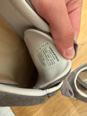 Gråa Vagabond sneakers i mocka - Snygga grå sneakers från Vagabond i mjuk mocka med klassisk låg profil. Skorna har matchande grå skosnören och vit sula. Perfekta för en stilren och avslappnad look. Insidan är ljus och bekväm, och designen är tidlös och enkel att matcha.