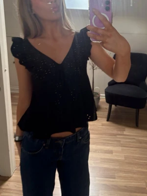 Svart blus med volangärmar - Helt oanvänd. Säljer en svart blus med v-ringning och volangdetaljer på ärmarna. Från SHEIN i storlek XS/34 nypris 118kr. 