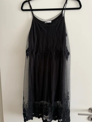 Svart klänning - Svart klänning från Promod. Storlek L men passar mer S/M. Är tidigare använd. Sista bilden visar detaljerna nertill. 