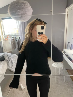 Svart fluffig stickad tröja H&M - Mysig svart stickad tröja från H&M i fluffigt material. Tröjan har lång ärm, rund halsringning och en avslappnad passform. Perfekt för lager-på-lager och enkel att matcha med jeans eller leggings.