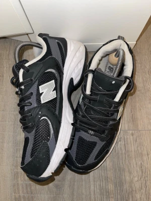 Svarta New Balance 530 sneakers - Snygga New Balance 530 sneakers i svart och grått med vita detaljer. Storlek 38 men mer som 36-37. Använda skor. 