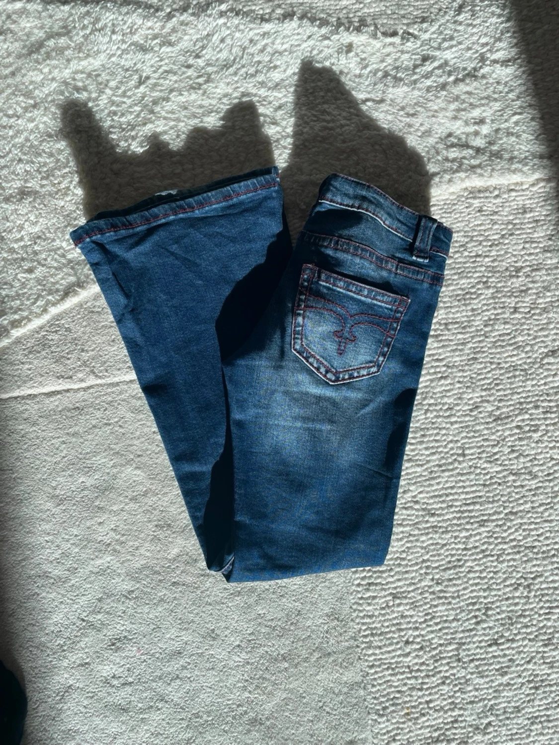 Blå bootcut jeans med broderad ficka