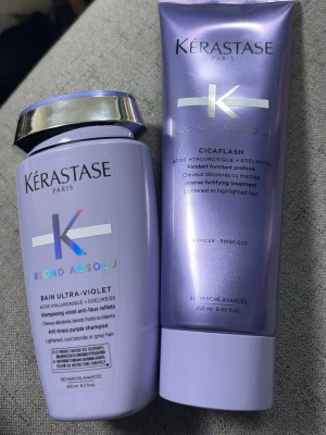 Kérastase Blond Absolu duo - Kérastase Blond Absolu Bain Ultra-Violet schampo och Cicaplash balsam, båda i lila plastförpackningar. Perfekt för blont, slingat eller grått hår. Innehåller hyaluronsyra och edelweiss för vård och skydd av håret.