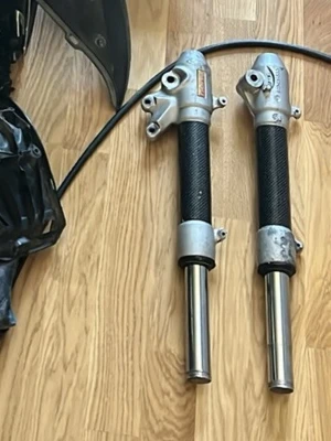 Framgafflar till Aerox - Säljer ett par framgafflar till Aerox i metall och svart material med silverfärgade detaljer.