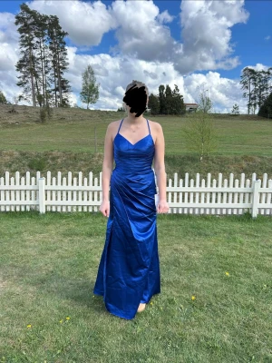 Blå balklänning med öppen rygg o slitts - Snygg blå balklänning från JJ’s House med både öppen rygg o slits. Den är helt oanvänd med lappen kvar så nytt skick!! Färgen heter Royal Blue. Storlek 36, byst 33.50 och waist 26.50. 💕