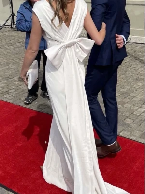 Vit balklänning med stor rosett - Superfin elegant klänning som passar perfekt till bal eller liknande. Helt slutsåld! Oanvänd med prislapp nypris 1700kr (inte mina bilder!)