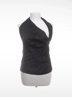 Svart halterneck topp i satin - Stilren svart halterneck topp i glansigt satinmaterial med djup v-ringning och knyt i ryggen. Perfekt för att skapa en trendig och elegant look. Toppen är ärmlös och har en smickrande passform.