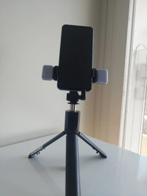 74cm Portabel Selfiepinne & Stativ med Dubbla Fyllnadslampor - Fånga den perfekta bilden varje gång med R1 Selfie Stick, ett mångsidigt 3-i-1-verktyg designat för innehållsskapare, resenärer och selfie-entusiaster          Design med dubbla funktioner: Använd den som en traditionell handhållen selfiepinne eller fäll ut de integrerade benen för att förvandla den till ett stabilt bordsstativ. ​Dubbla LED-fyllnadslampor: Setet innehåller två löstagbara, uppladdningsbara LED-lampor som kan fästas på mobilhållaren för att ge professionell belysning i mörka miljö