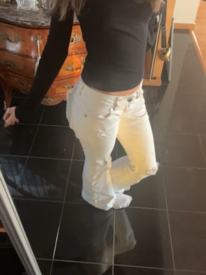 Vita bootcut jeans med slitningar - Säljer ett par vita bootcut jeans med slitningar på knäna och låret. Jeansen är från gina och jag säljer dom för dom är lite för stora för mig. Använda några gånger men inget som märks så mycket förutom att dom har väldigt lite slitning längst ner. Skriv om ni undrar något eller vill ha bild