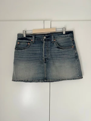 Jeanskjol - Kort jeanskjol från Levis i storlek 30. Använd men i väldigt bra skick! Den passar tyvärr mig inte längre därför säljer jag den.