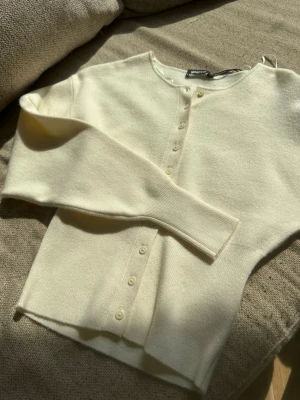 Krämvit kofta från Gina Tricot - Snygg krämvit kofta från Gina Tricot med rund halsringning och knappar framtill. Den är i storlek xs och har lapparna kvar💕