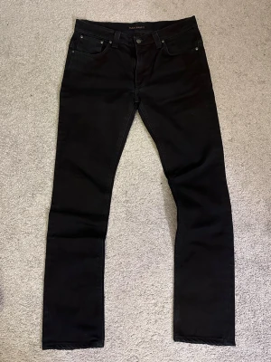 Nudie Jeans ”Tape Ted” - Säljer ett par jeans från Nudie Jeans i modellen ”Tape Ted” i färgen ”Black Ring”. Modellen är taper fit så lite mer åt det slim hållet. Storlek W34L34