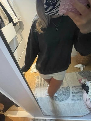 Svart sweatshirt  - En svart sweatshirt med klassisk passform och långa ärmar. Tröjan har en enkel design utan synliga loggor eller tryck och är tillverkad i ett mjukt material som känns skönt mot huden. Perfekt för en chill och avslappnad stil.
