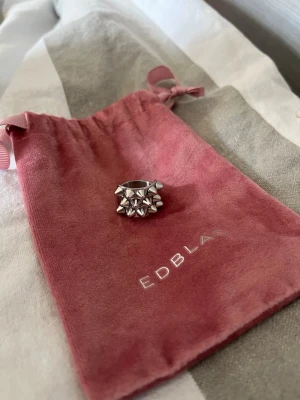 Ring från Edblad - Cool och chunky ring i blankt silverfärgat metall från Edblad. Ringen har en unik design med flera små pyramidformade nitar som ger en edgy och modern känsla. Perfekt accessoar för att lyfta din stil.