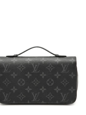 Louis Vuitton Monogram Eclipse Zippy XL Wallet - Snygg svart handväska från Louis Vuitton med klassiskt monogrammönster i grått. Väskan har en stilren rektangulär form, ett litet handtag upptill och silverfärgade metalldetaljer. Tillverkad i tåligt lädermaterial som ger en lyxig känsla.