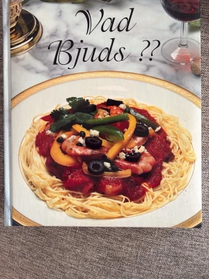 Vad Bjuds ?? Kokbok - Kokboken 'Vad Bjuds ??' bjuder på över 1200 inspirerande recept med färgbilder och steg-för-steg instruktioner. Perfekt för dig som vill laga allt från vardagsmat till festmåltider. Inbunden bok med matiga bilder på omslaget och baksidan.