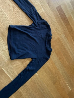 Svart långärmad magtröja från Gina Tricot - En enkel och stilren svart långärmad magtröja  från Gina Tricot. Den är i ett mjukt, stretchigt material
