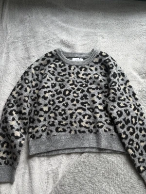 Leopardmönstrad stickad tröja - Säljer en grå stickad tröja med leopardmönster från Zara, storlek 152 och är i väldigt bra skick! 