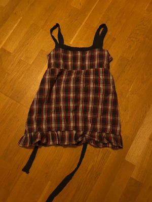 Rutig babydolltopp - Supersöt babydolltopp med röd, svart och vit rutig design. knytband där bak för att den ska sitta tajt beroende på hur du vill ha den❤️❤️ Fråga bara för mer bilder!!