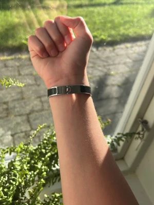 Svart läderarmband med metallspänne - (F A K E)Snyggt svart armband i läder med ett stilrent metallspänne. Armbandet har en enkel och modern design som passar till många olika stilar. Perfekt accessoar för dig som gillar minimalistiska smycken.