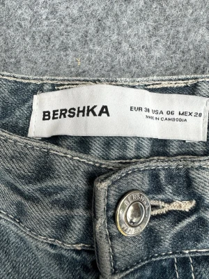 Blå raka jeans från Bershka - Säljer ett par klassiska blå grå jeans från Bershka i rak modell. Jeansen har fem fickor, bälteshällor och knappgylf. Materialet är slitstark denim i en tvättad ljusblågrå färg som ger en avslappnad look. Slitna i hälarna.
