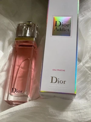 Dior Addict Eau Fraîche parfym 100ml - Dior Addict Eau Fraîche är en elegant parfym med fräsch och blommig doft. Flaskan är rektangulär i genomskinligt glas med rosa vätska och silverdetaljer. Kommer i originalförpackning med holografiska detaljer och tydlig Dior-logga.