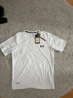 Under Armour T-shirt  - Mycket fin vit under Armour T-shirt. Oanvänd. Storlek L