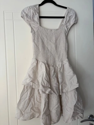 Volangklänning med puffärm - Beige och söt klänning som passar perfekt till sommaren. Ifrån HM och i storlek S. Endast använd en gång.